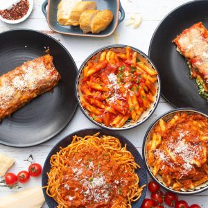 Different pasta dishes on a white table