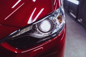 Driver side headlight on red Mazda