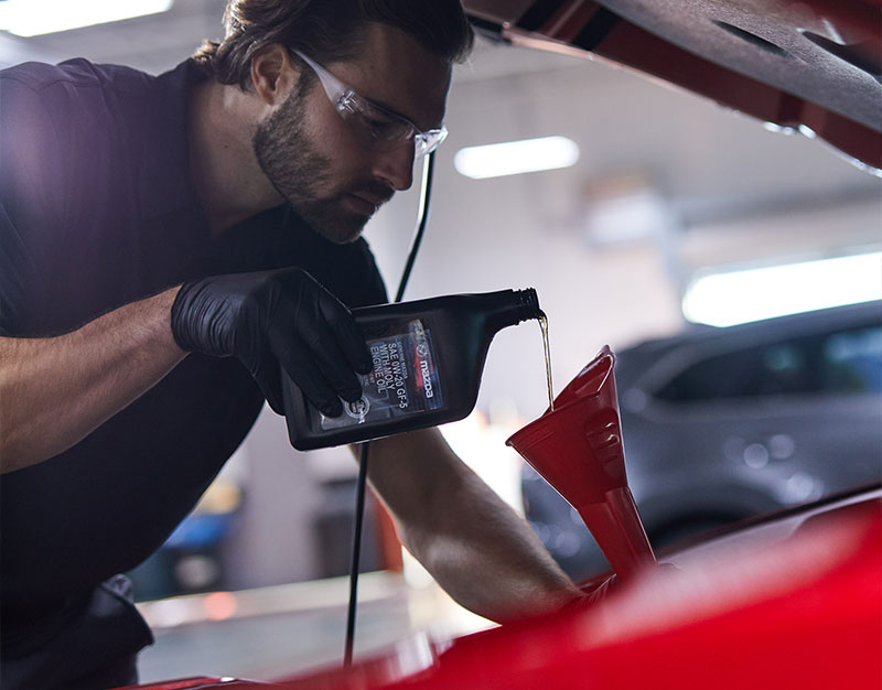 A Mazda Certified Technician performing an oil change